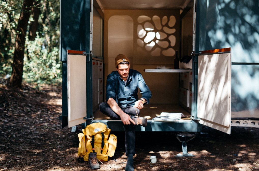 Man sitting in the back of his tiny house