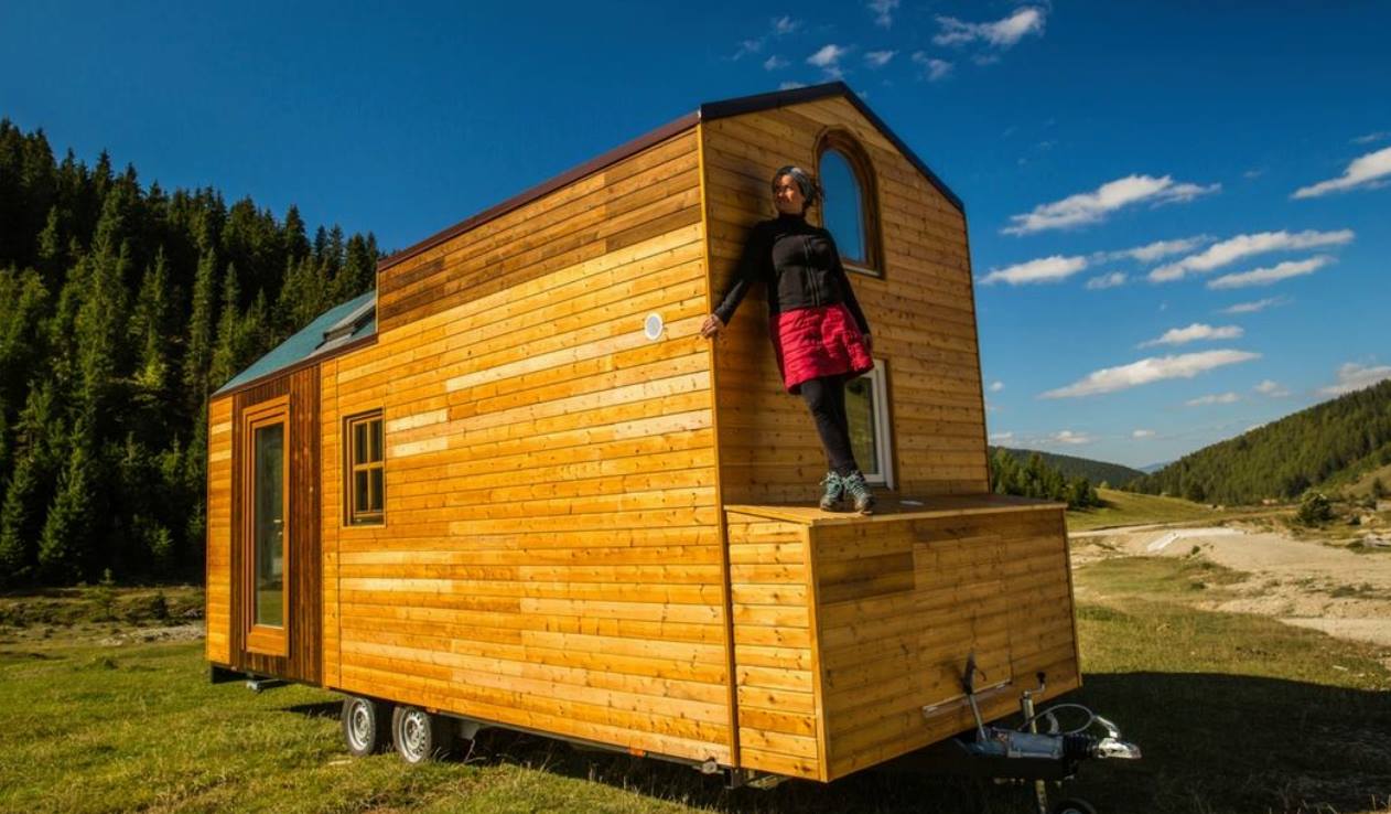 Gabriela standing on her Tiny House in Romania