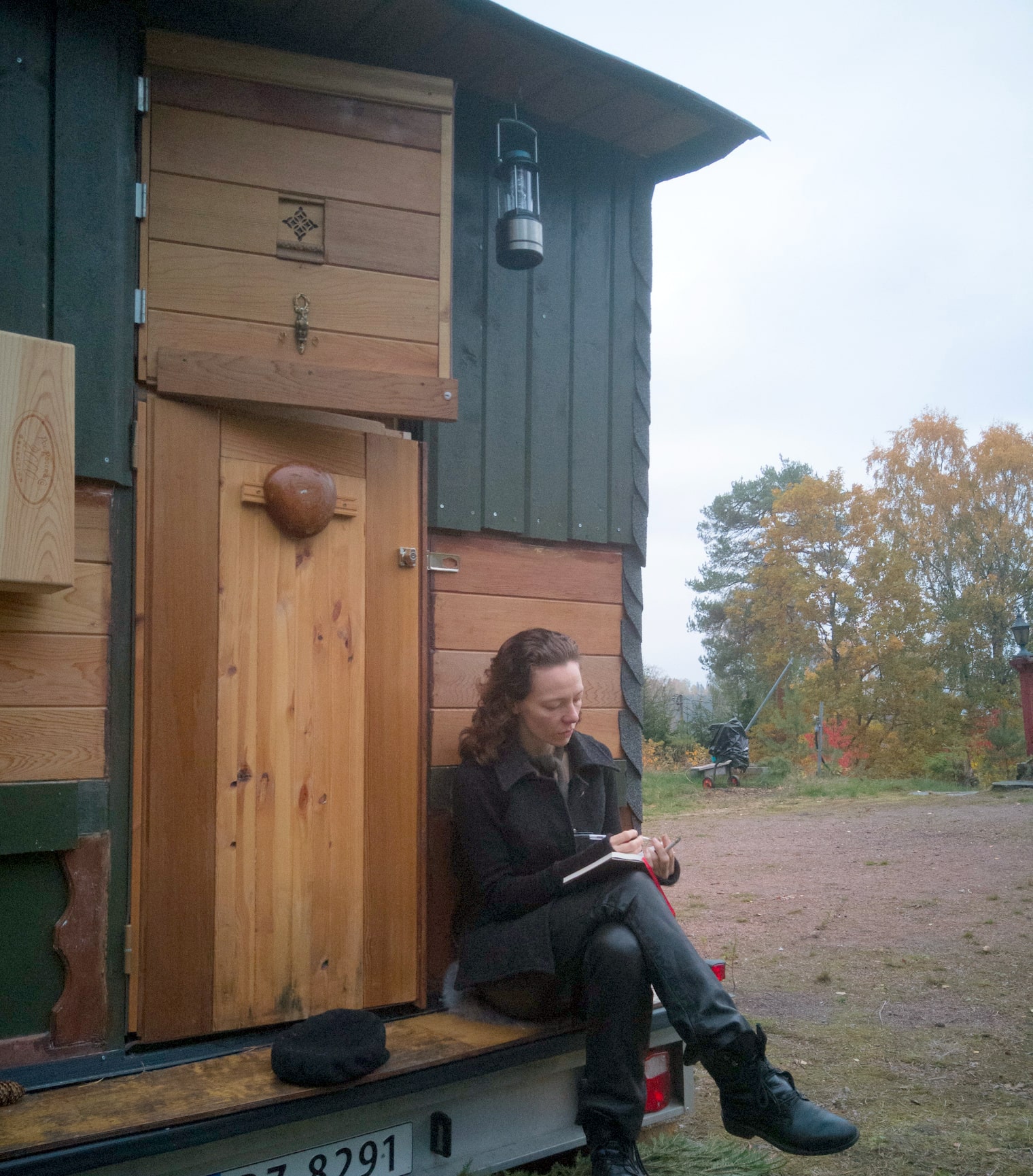 Tone sitting in front of her Tiny House Norway